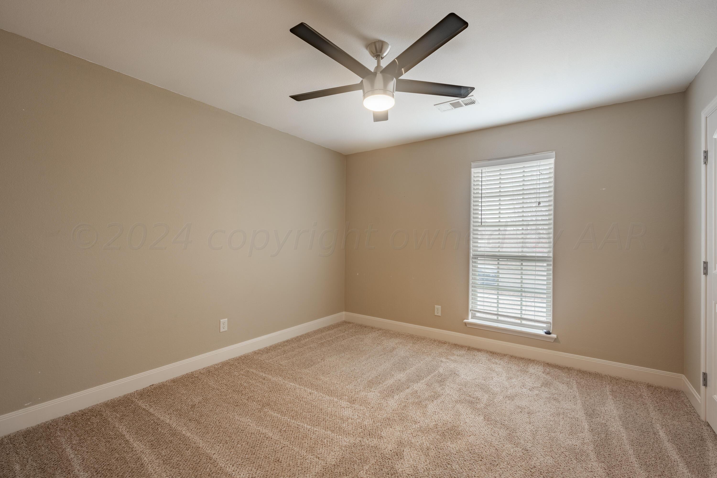 4512 Ross Street Amarillo, TX 79118 - Photo 12 of 24 an empty room with ceiling fan and windows