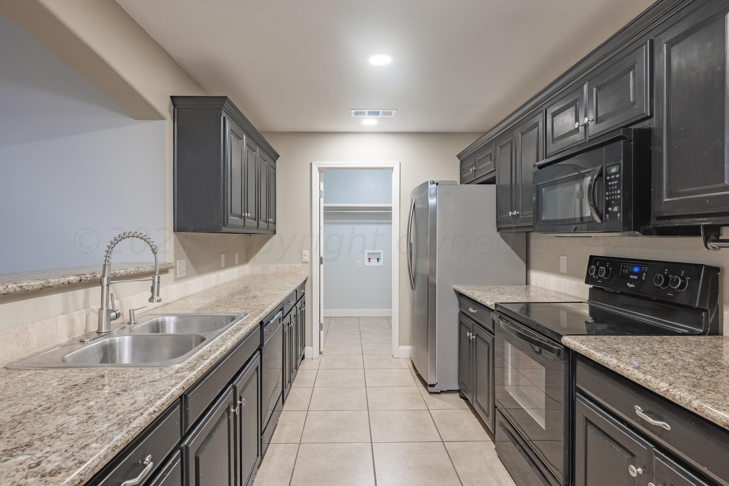 4512 Ross Street Amarillo, TX 79118 - Photo 4 of 24 a kitchen with stainless steel appliances granite countertop a sink stove and refrigerator