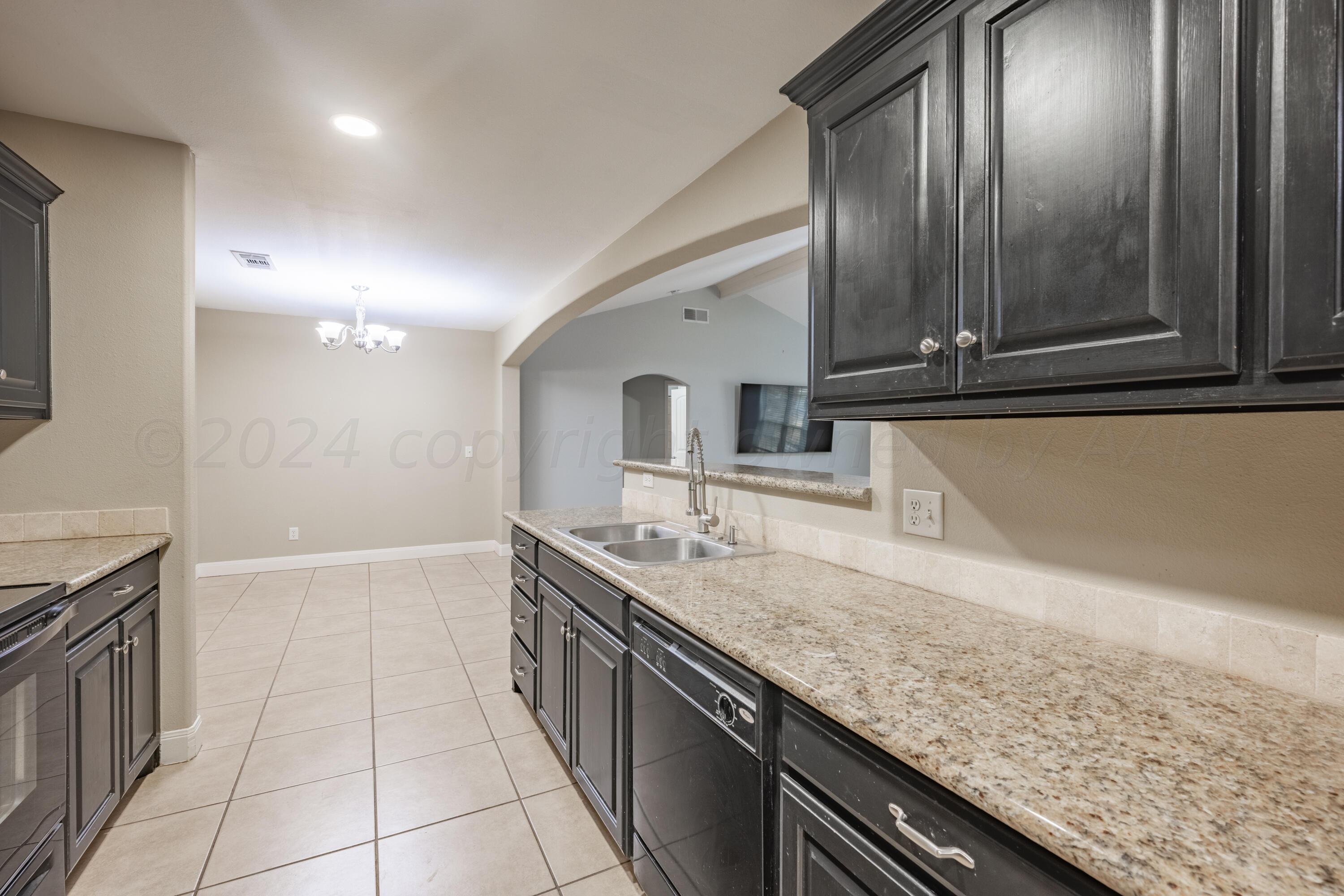 4512 Ross Street Amarillo, TX 79118 - Photo 5 of 24 a kitchen with stainless steel appliances granite countertop a sink and cabinets