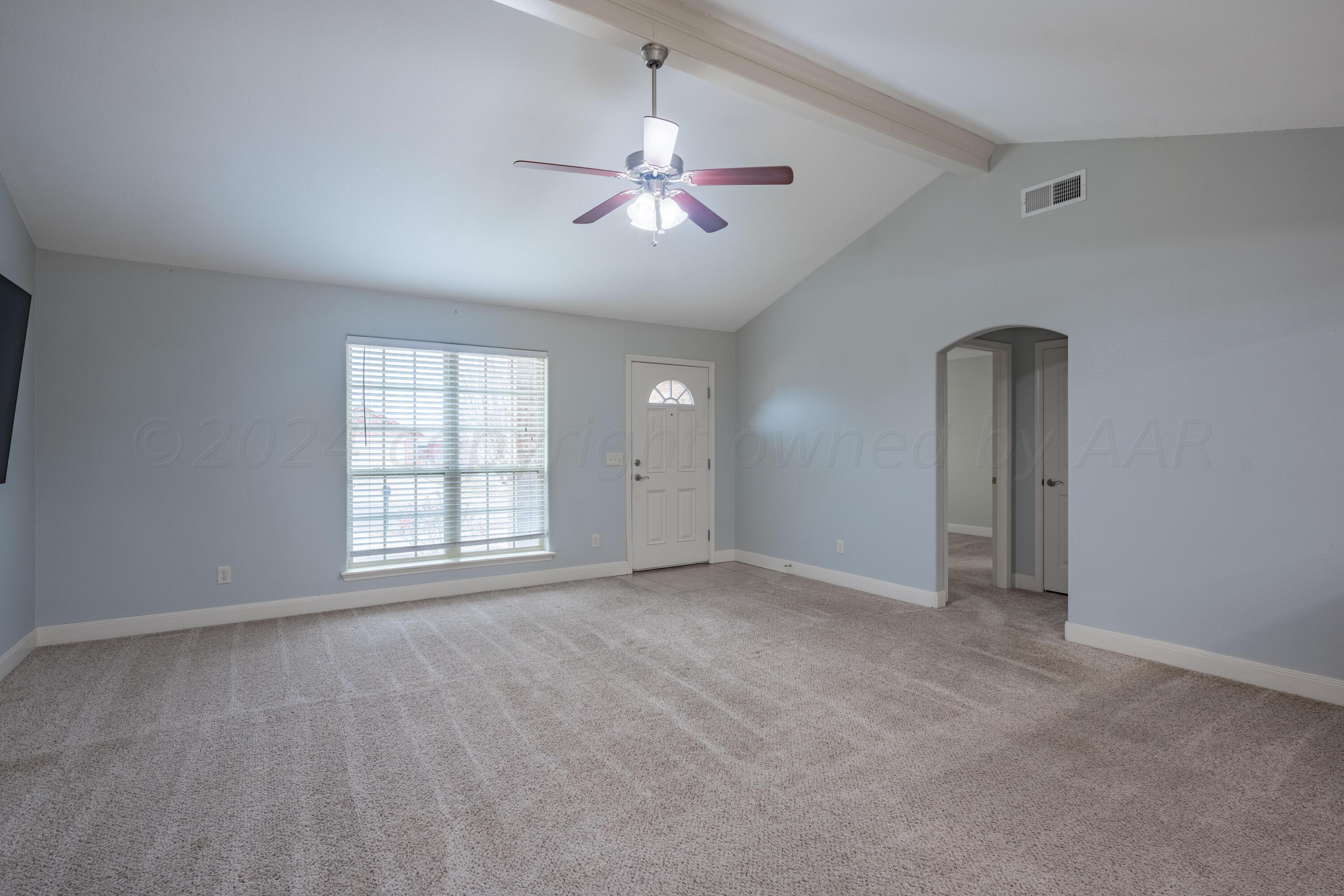 4512 Ross Street Amarillo, TX 79118 - Photo 6 of 24 an empty room with chandelier fan and windows