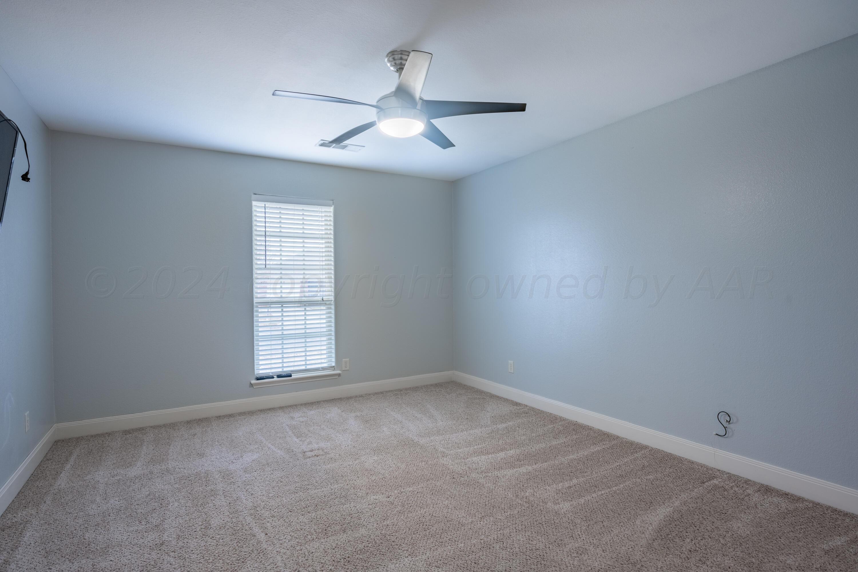 4512 Ross Street Amarillo, TX 79118 - Photo 8 of 24 an empty room with windows and chandelier fan