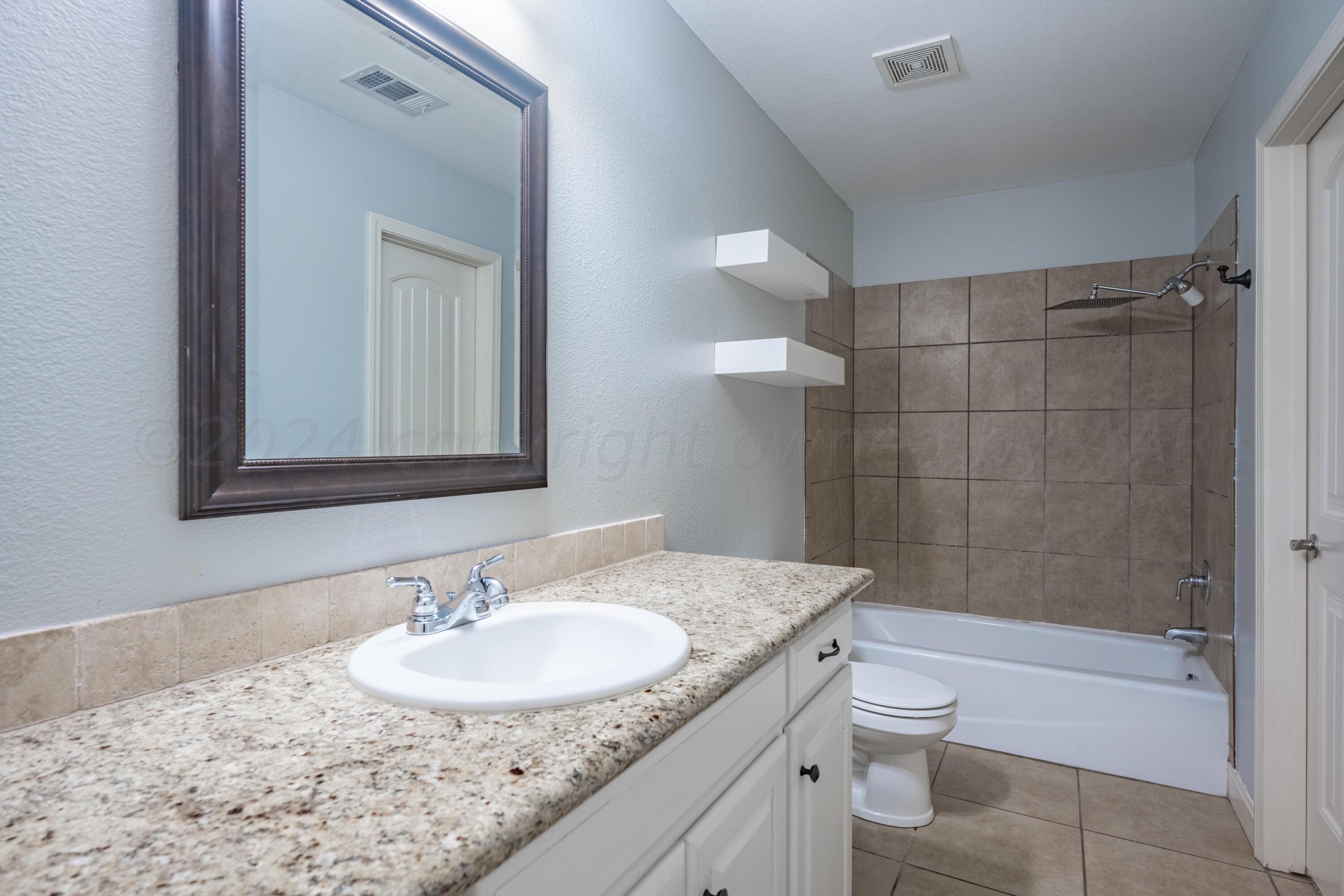 4512 Ross Street Amarillo, TX 79118 - Photo 10 of 24 a bathroom with a granite countertop sink toilet and shower