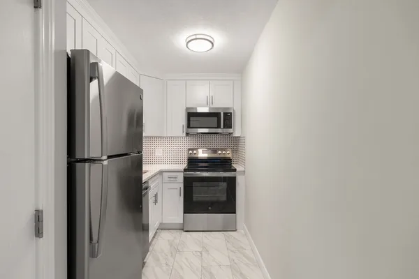 a kitchen with a refrigerator and a stove