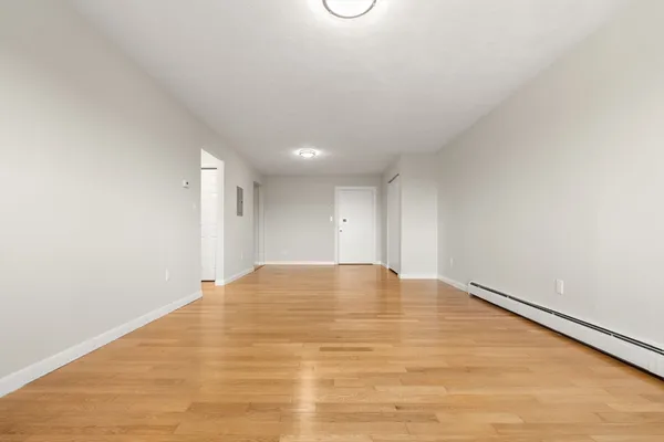 a view of an empty room with wooden floor
