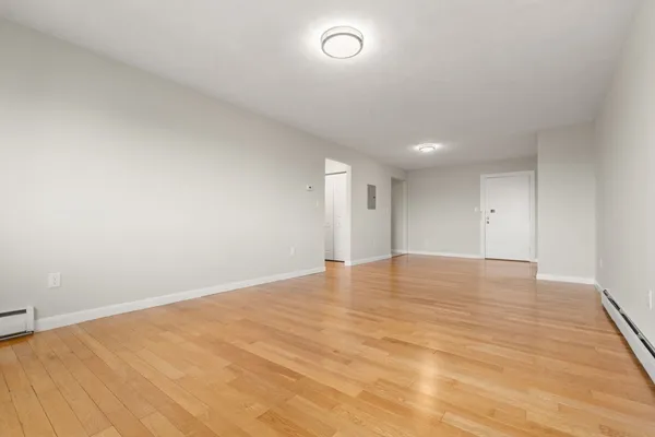 a view of empty room with wooden floor