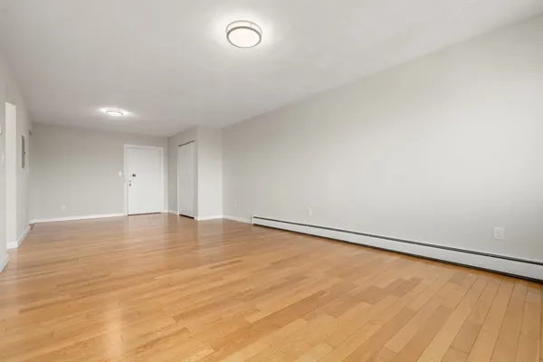 a view of an empty room with wooden floor