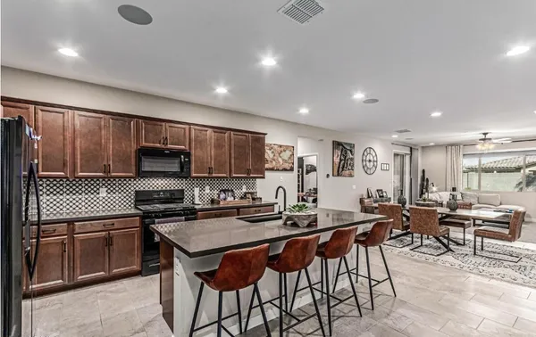 a kitchen with stainless steel appliances a table and chairs in it