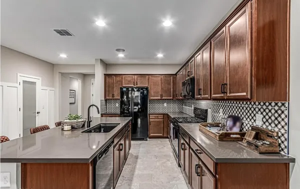 a kitchen with granite countertop a sink stove and refrigerator