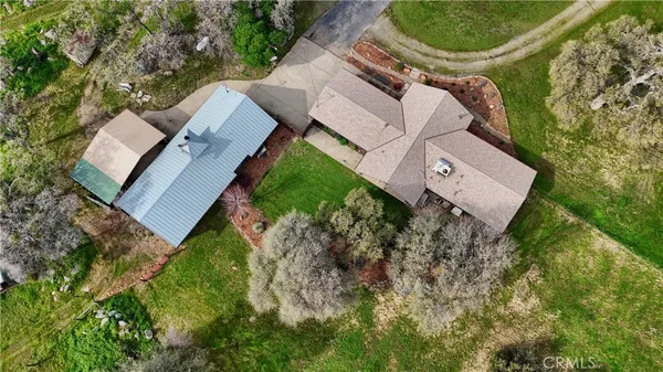an aerial view of residential houses with outdoor space and trees