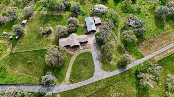 an aerial view of a house with a yard lake and outdoor seating