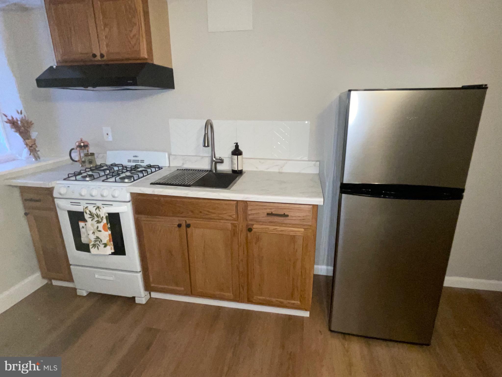 2301 Mosher Street Baltimore, MD 21216 - Photo 19 of 30 a kitchen with stainless steel appliances granite countertop a refrigerator a stove a sink and a microwave