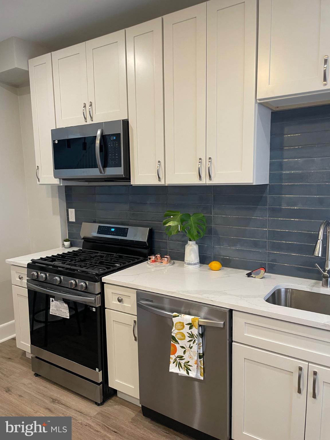 2301 Mosher Street Baltimore, MD 21216 - Photo 4 of 30 a kitchen with stainless steel appliances a stove a microwave and cabinets