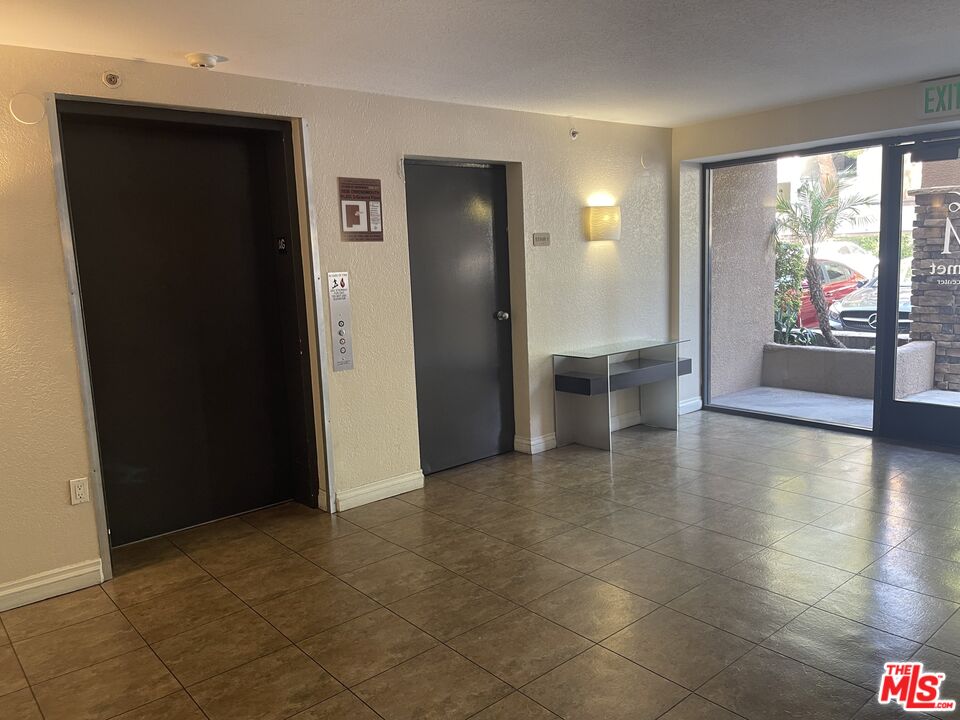 5530 Owensmouth Avenue, Unit 223 Woodland Hills, CA 91367 - Photo 3 of 21 an empty room with large windows and view of kitchen