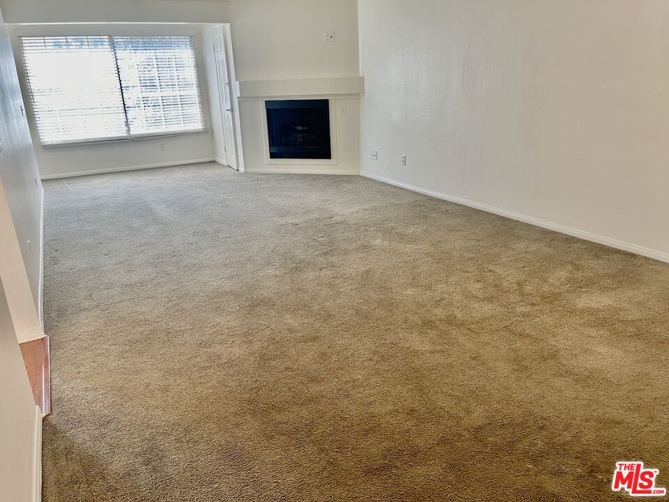 5530 Owensmouth Avenue, Unit 223 Woodland Hills, CA 91367 - Photo 5 of 21 an empty room with windows and fireplace