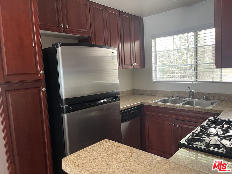 5530 Owensmouth Avenue, Unit 223 Woodland Hills, CA 91367 - Photo 7 of 21 a kitchen with a sink stove and window