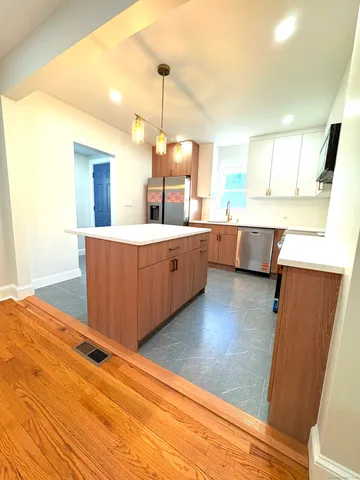 a living room with hard wood floors and a kitchen