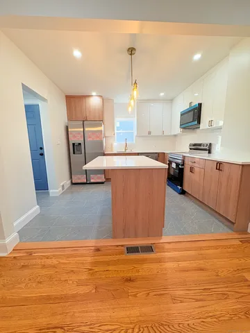 a large kitchen with stainless steel appliances granite countertop a granite counter tops and a view of living room