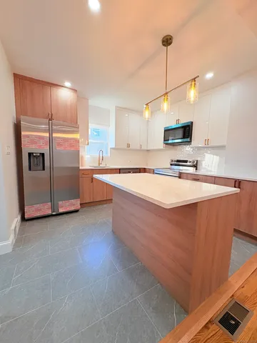 a kitchen with stainless steel appliances granite countertop a sink a stove and a refrigerator