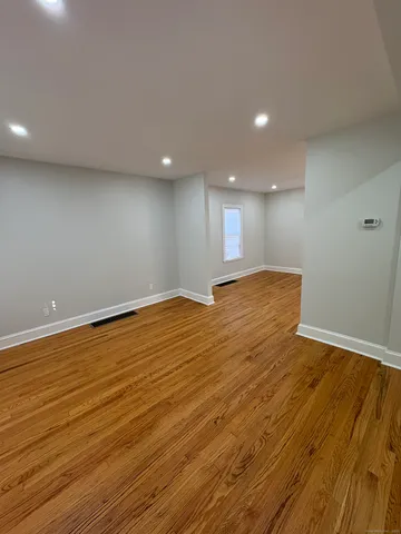 an empty room with wooden floor and entrance