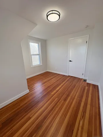 a view of a room with wooden floor and window