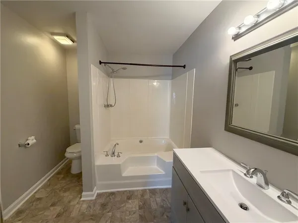 a bathroom with a tub sink toilet and a mirror