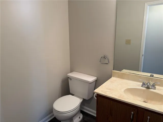 a bathroom with a toilet a sink and mirror