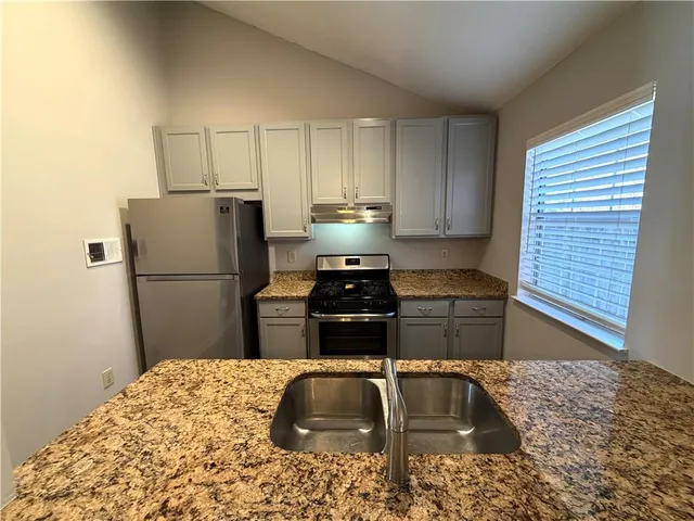 a kitchen with a refrigerator and a sink
