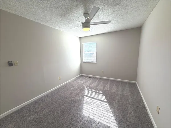 an empty room with a window and a ceiling fan