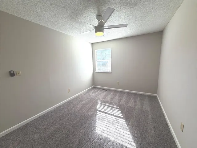 an empty room with a window and a ceiling fan