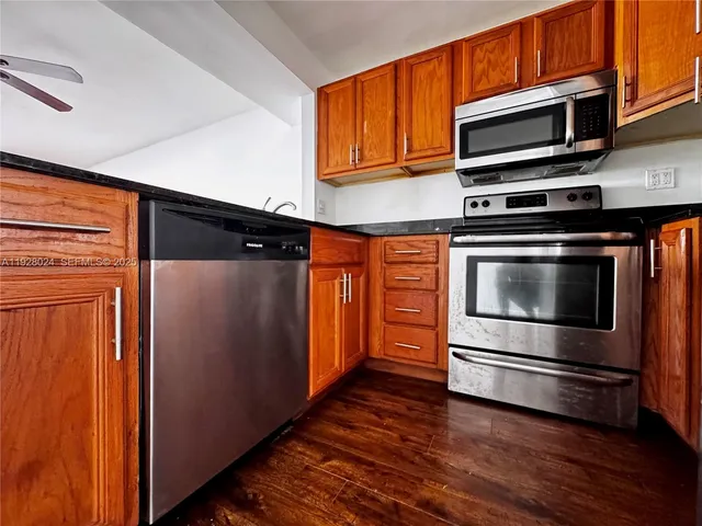 a kitchen with stainless steel appliances and wooden cabinets