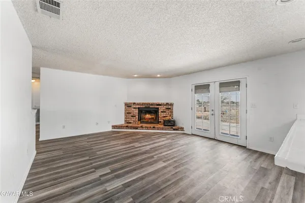 a view of empty room with wooden floor and fireplace