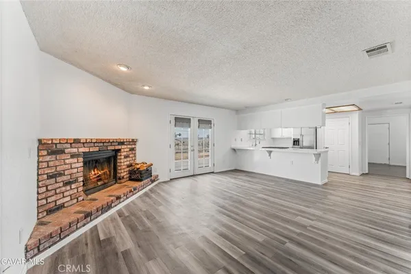 a view of empty room with wooden floor and fireplace