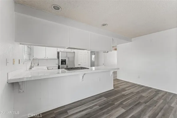 a kitchen with a sink cabinets stainless steel appliances and a window