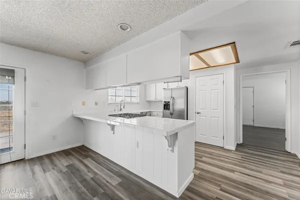a kitchen with stainless steel appliances granite countertop a sink a stove and cabinets