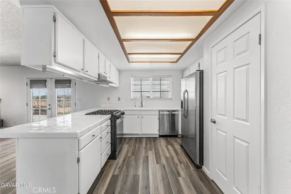 a kitchen with stainless steel appliances granite countertop a stove and a white cabinets