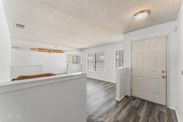 an empty room with wooden floor and window