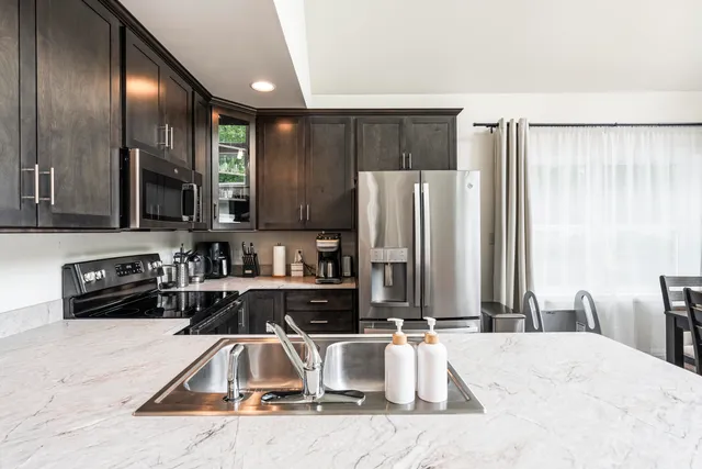 a kitchen with granite countertop a refrigerator and a sink