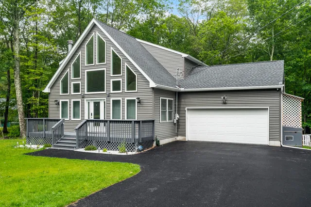 a front view of a house with a garden and yard