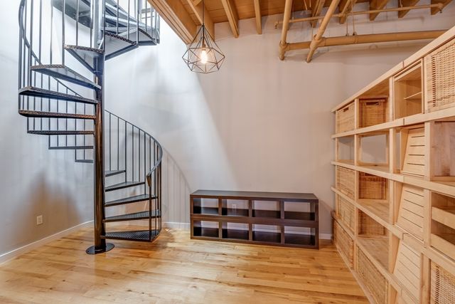 a view of a stairs and an empty room with wooden floor
