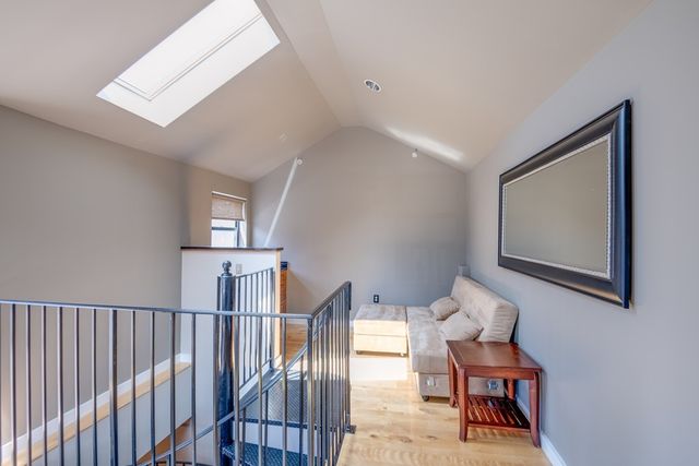 a view of a hallway with wooden floor and a livingroom