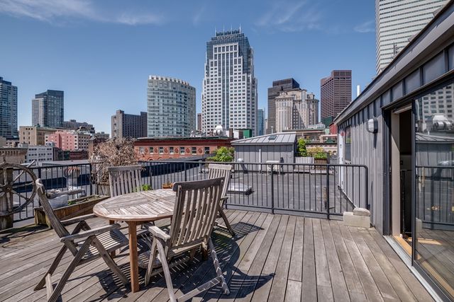 a view of a roof deck with table and chairs