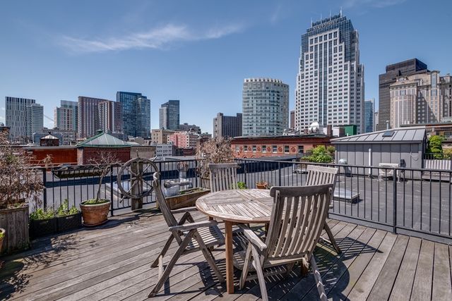 a view of a roof deck with table and chairs