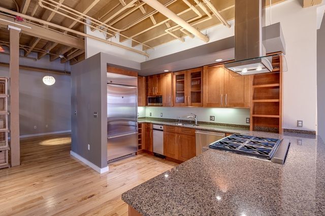 a kitchen with stainless steel appliances granite countertop a stove a sink and a refrigerator