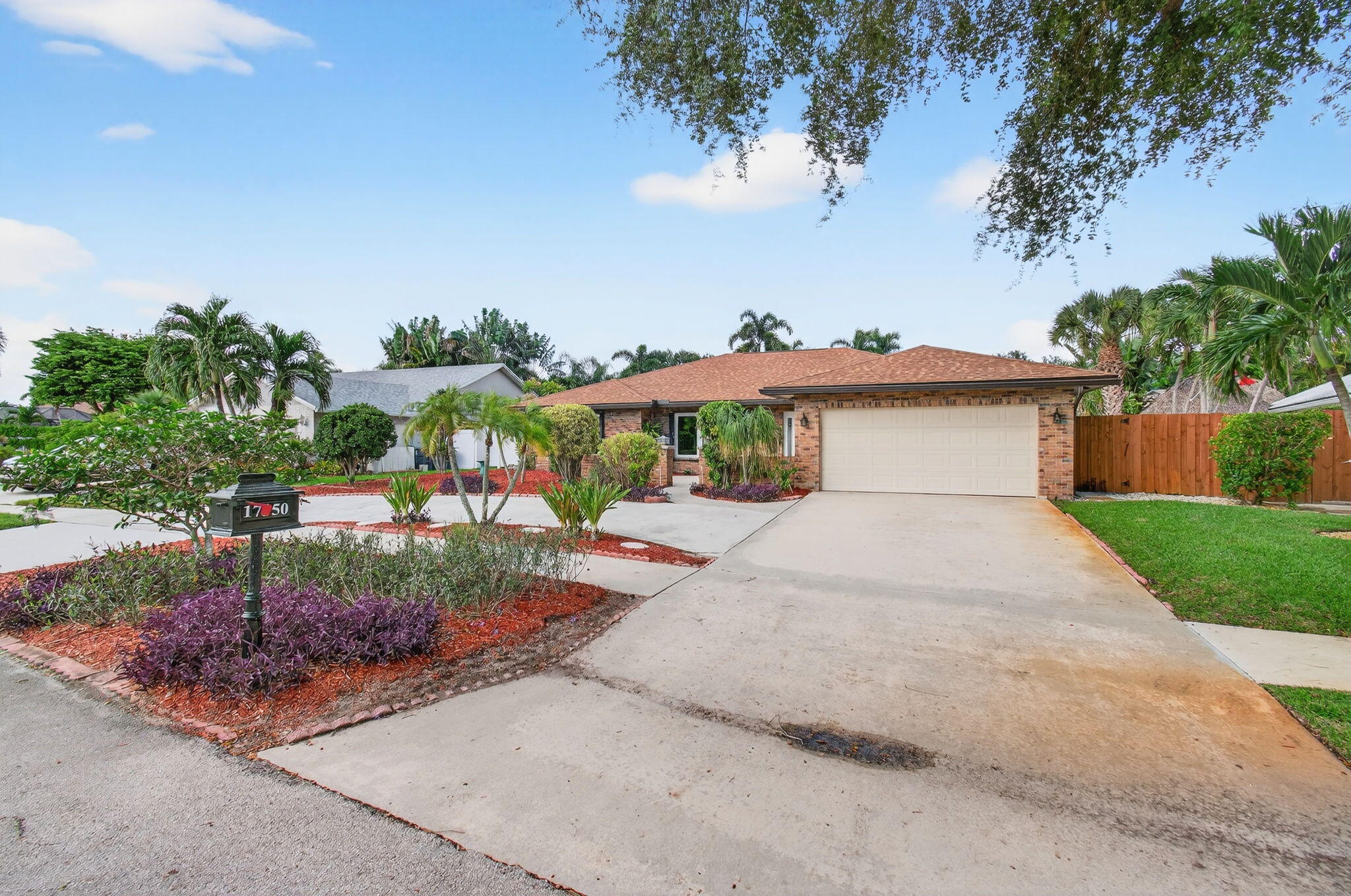 17350 Springtree Lane Boca Raton, FL 33487 - Photo 1 of 83 a view of a house with a yard and table and chairs under an umbrella