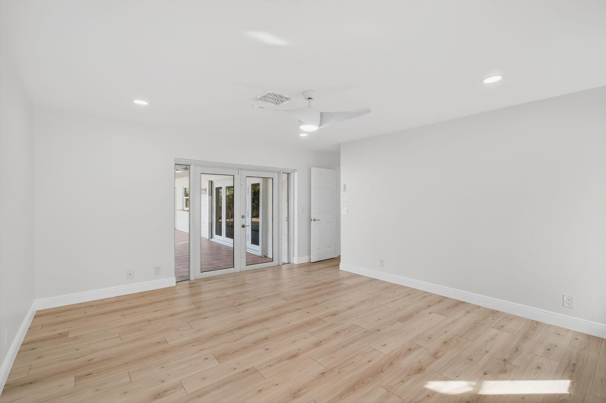 17350 Springtree Lane Boca Raton, FL 33487 - Photo 36 of 83 a view of an empty room with wooden floor and a ceiling fan
