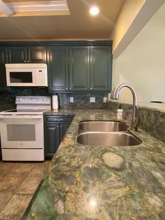 a kitchen with a sink and a stove top oven