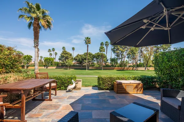 an outdoor sitting area with furniture and garden