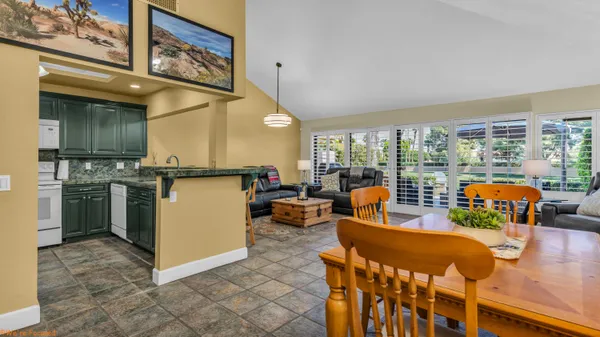 a living room filled with furniture and large windows