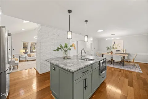 a view of a kitchen counter top space with furniture and wooden floor