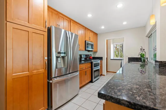 a kitchen with stainless steel appliances granite countertop a refrigerator and a sink